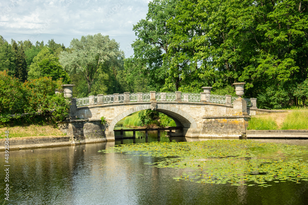 The view of the 19th century stone Visconti bridge over the Slavyanka River in summertime in Pavlovsky Park, Saint Petersburg, Russia