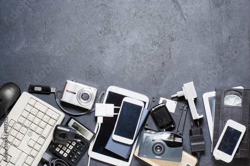 Old electronic devices on a dark background. The concept of recycling and disposal of electronic waste. Copy space photo