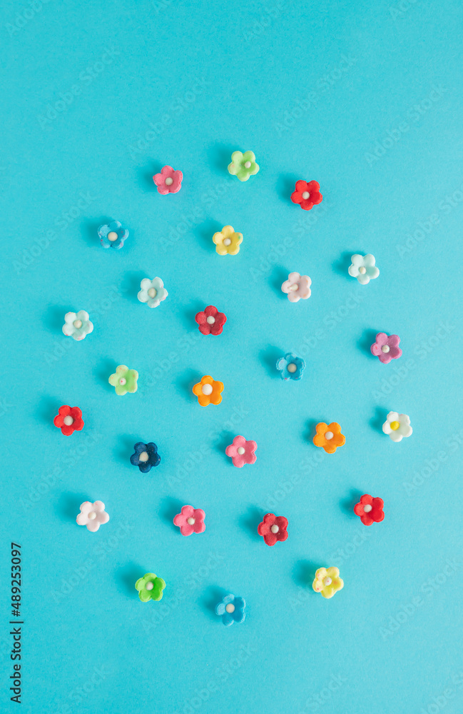 Colorful Easter egg made of eatable sugar kitchen flowers pattern on a vibrant blue background. Colorful creative spring flat lay concept. Colorful Easter egg made of eatable sugar kitchen flowers pattern on a vibrant blue background. Colorful creative spring flat lay concept.