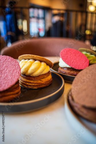 Colourful danish fastelavnsbolle with jam, whipped cream and almond paste in laminated pastry dough with powdered sugar on top served in Copenhagen, Denmark in a cafe bakery Andersen Bakery