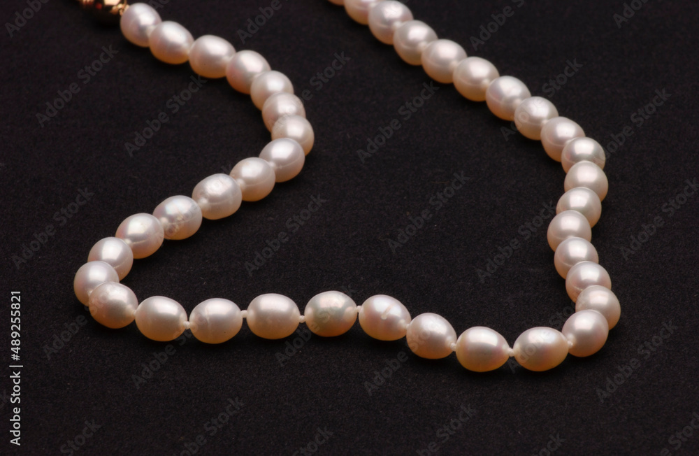 Pearl necklace on matte black background. Pearl necklace on matte black background.