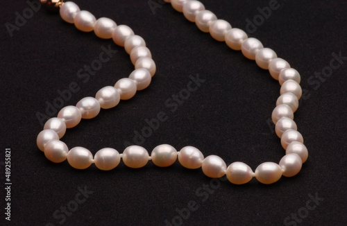 Pearl necklace on matte black background.