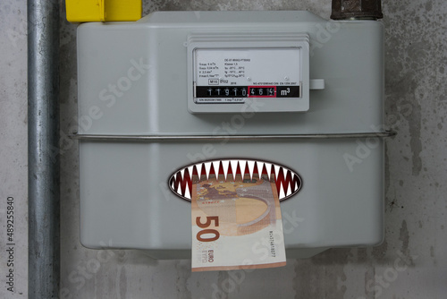 A gas meter that eats up a 50 euro note. Electricity, gas, oil, energy prices have risen exorbitantly and are eating a hole in the household budgets of millions of people. photo