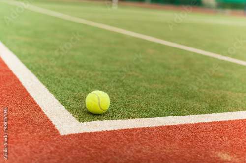 Tennis ball on the court at the dividing line. Artificial tennis court. © yallowww