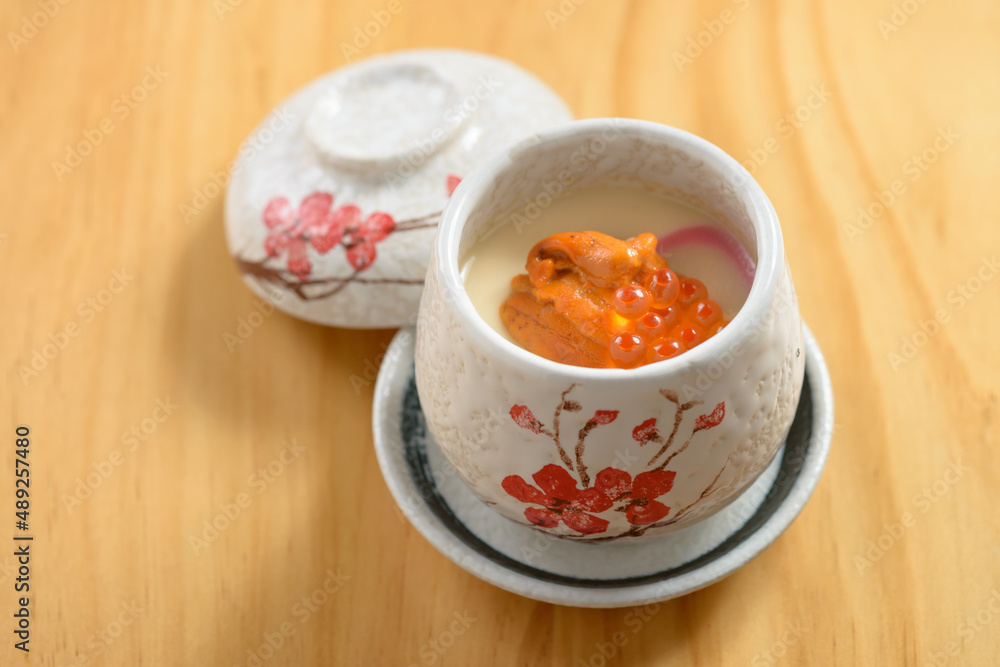 japanese cuisine Uni Chawanmushi in tea bowl isolated on wooden background top view japanese cuisine Uni Chawanmushi in tea bowl isolated on wooden background top view