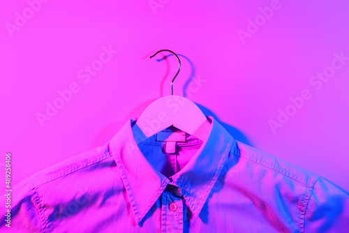 Clothes hanger with shirt on dark color background