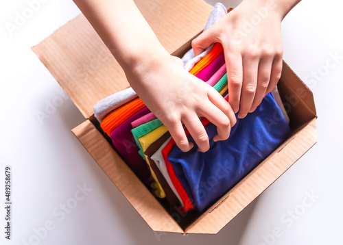 Folded colorful clothes in a box. Home organizing. Domestic vertical storage.