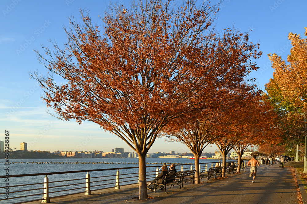 Autumn embankment of Hudson River at sunset. New York City - obrazy, fototapety, plakaty 