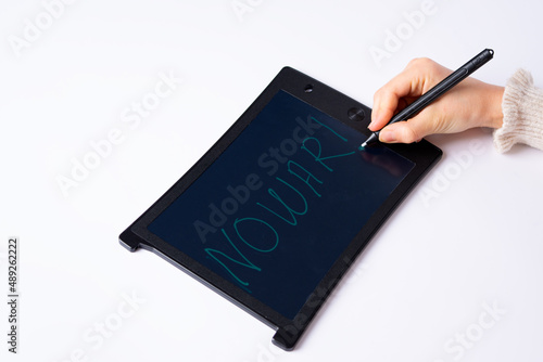  child writes on tablet with pen, no war, white background, hand with black pen writes