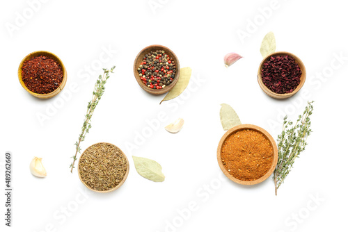 Composition with wooden bowls of aromatic spices on white background