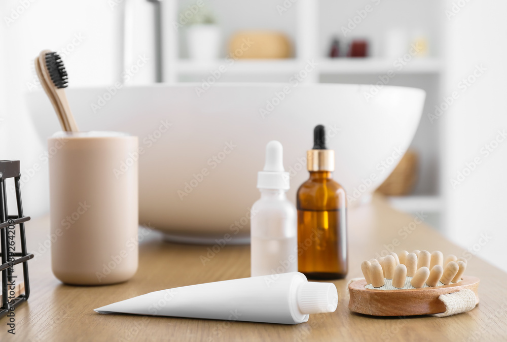 Toothpaste and massage body brush on table in bathroom