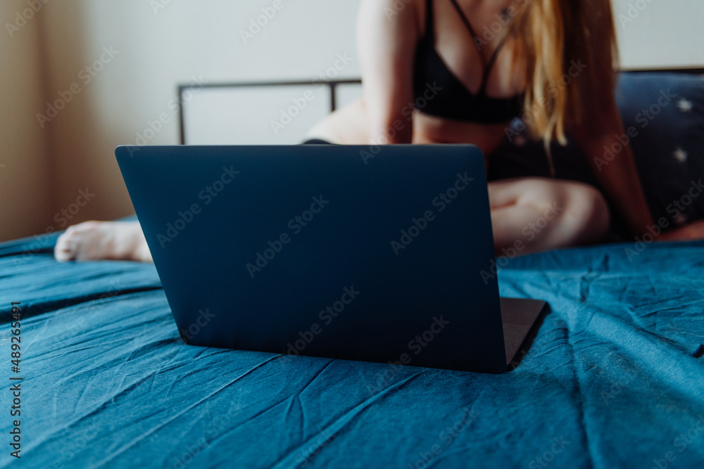 Webcam model. Young sexy woman using laptop on the bed. Flirting, online  sex-chat, nudes concept. Stock Photo | Adobe Stock