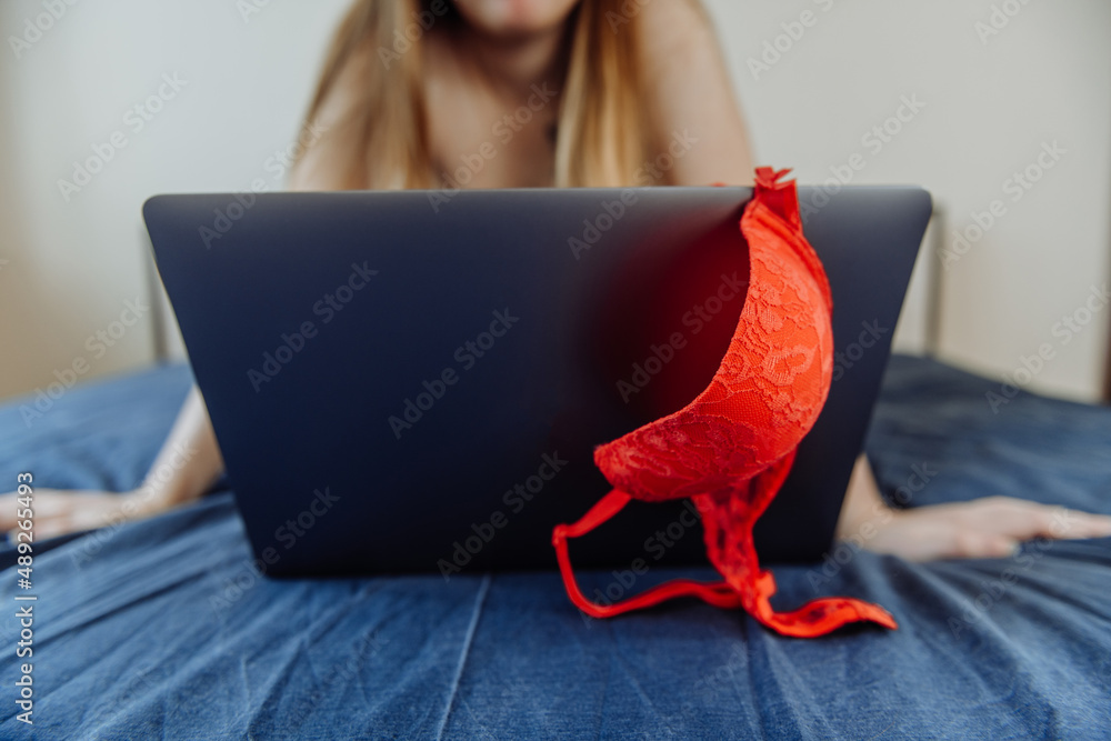 Webcam model. Young sexy woman using laptop on the bed. Flirting, online  sex-chat, nudes concept. Stock Photo | Adobe Stock