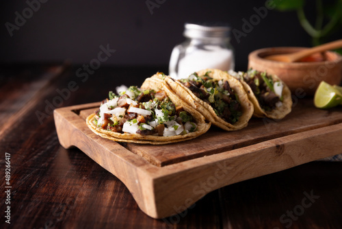 Tacos de Suadero. Fried meat in a corn tortilla. Street food from CDMX, Mexico, traditionally accompanied with cilantro, onion and spicy red sauce photo