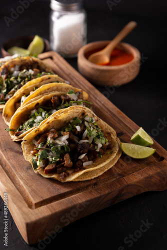 Tacos de Suadero. Fried meat in a corn tortilla. Street food from CDMX, Mexico, traditionally accompanied with cilantro, onion and spicy red sauce photo