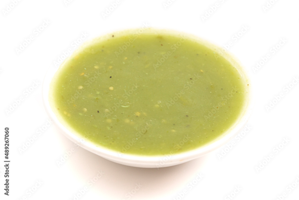 A Small Bowl of Green Salsa Verde on a White Background A Small Bowl of Green Salsa Verde on a White Background