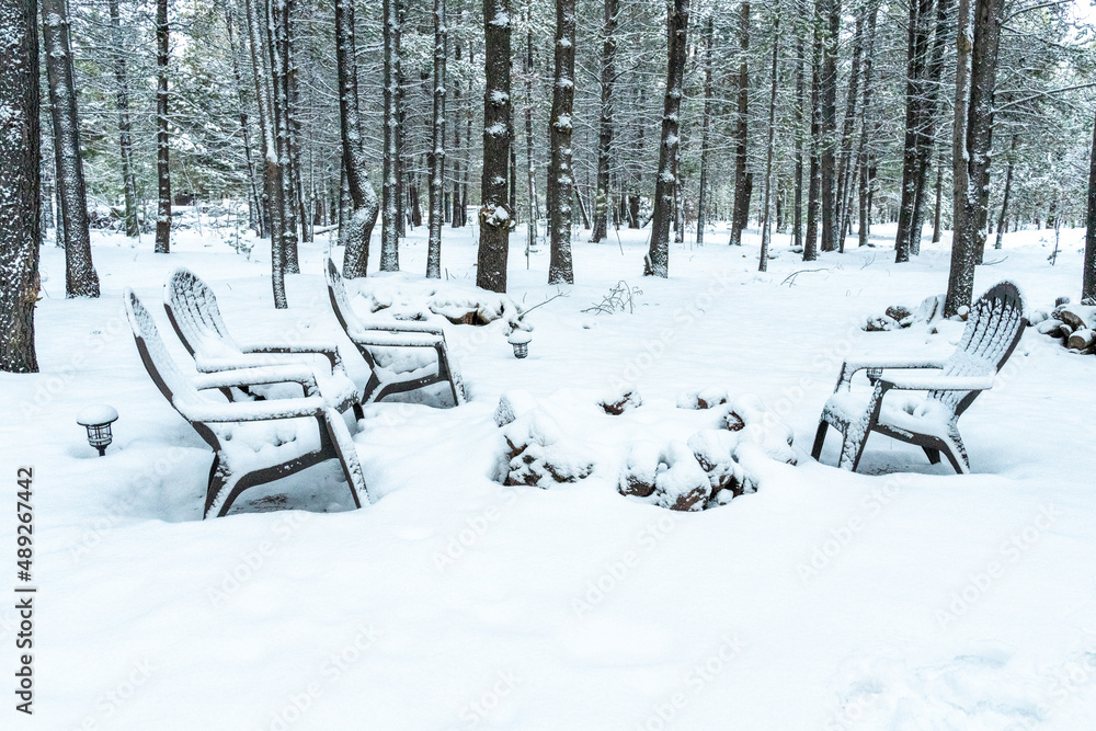 Picnic chairs in the snow with firepit