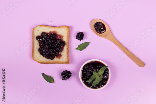 Healthy breakfast. Blackberry jam with toast bread and fresh blackberry on pink background. Flat lay, top view image. photo