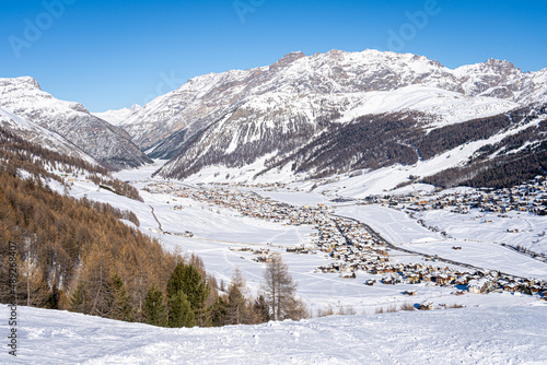 Scenic view of Livigno village in Sondrio province, Italy. Popular skiing resort in European Alps. Snowcapped mountains, houses and ski slopes © hopsalka