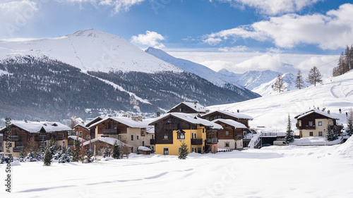 Scenic view of Livigno village in Sondrio province, Italy. Popular skiing resort in European Alps. Snowcapped mountains, houses and ski slopes