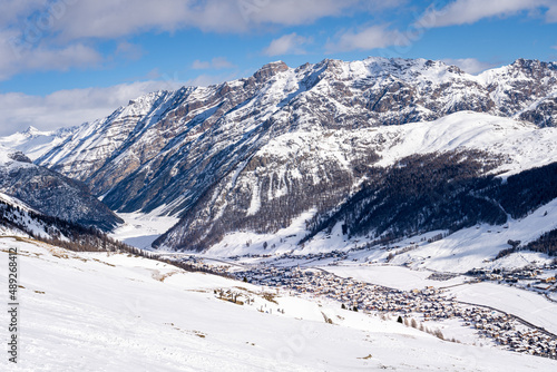 Scenic view of Livigno village in Sondrio province, Italy. Popular skiing resort in European Alps. Snowcapped mountains, houses and ski slopes © hopsalka