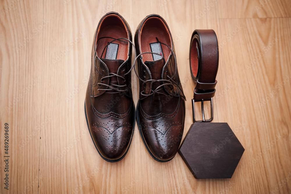 Leather men's shoes, a pair of gold wedding rings in a wooden box. Groom's accessories Leather men's shoes, a pair of gold wedding rings in a wooden box. Groom's accessories