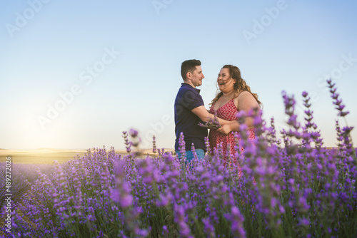 couple looking at each other and laughing in a lavender field.