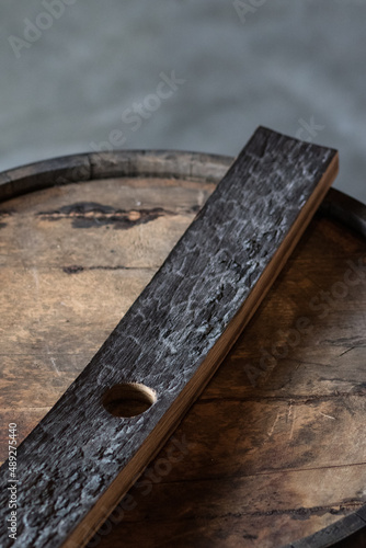 charcoal inside of barrel stave sitting on top of wooden bourbon whiskey barrel photo