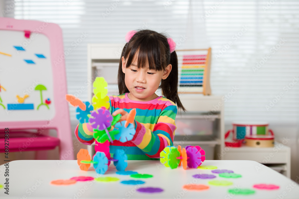 Fototapeta premium young irl playing creative toy blocks at home