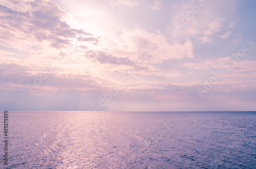 Picturesque seascape background. Pink clouds and blue sea