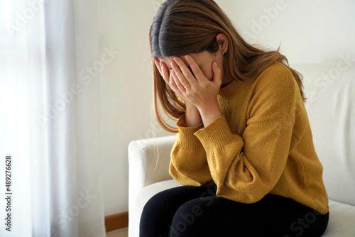 Young sad beautiful woman suffering depression crying worried at home photo