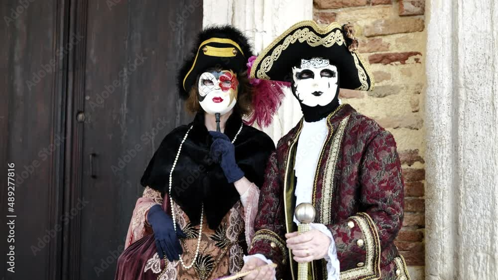 Venice, Italy - February 2022 - carnival masks are photographed with tourists in San Marco square Venice, Italy - February 2022 - carnival masks are photographed with tourists in San Marco square
