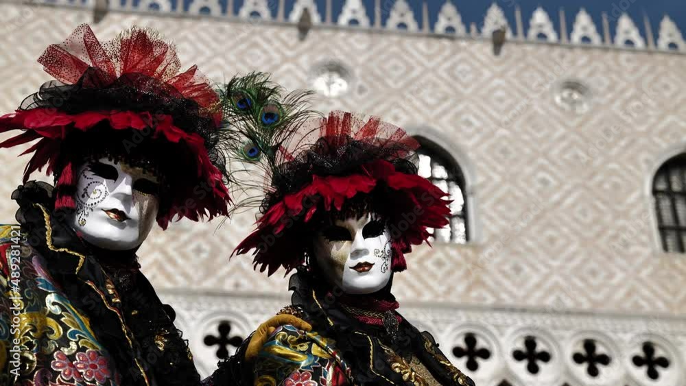 Venice, Italy - February 2022 - carnival masks are photographed with tourists in San Marco square Venice, Italy - February 2022 - carnival masks are photographed with tourists in San Marco square