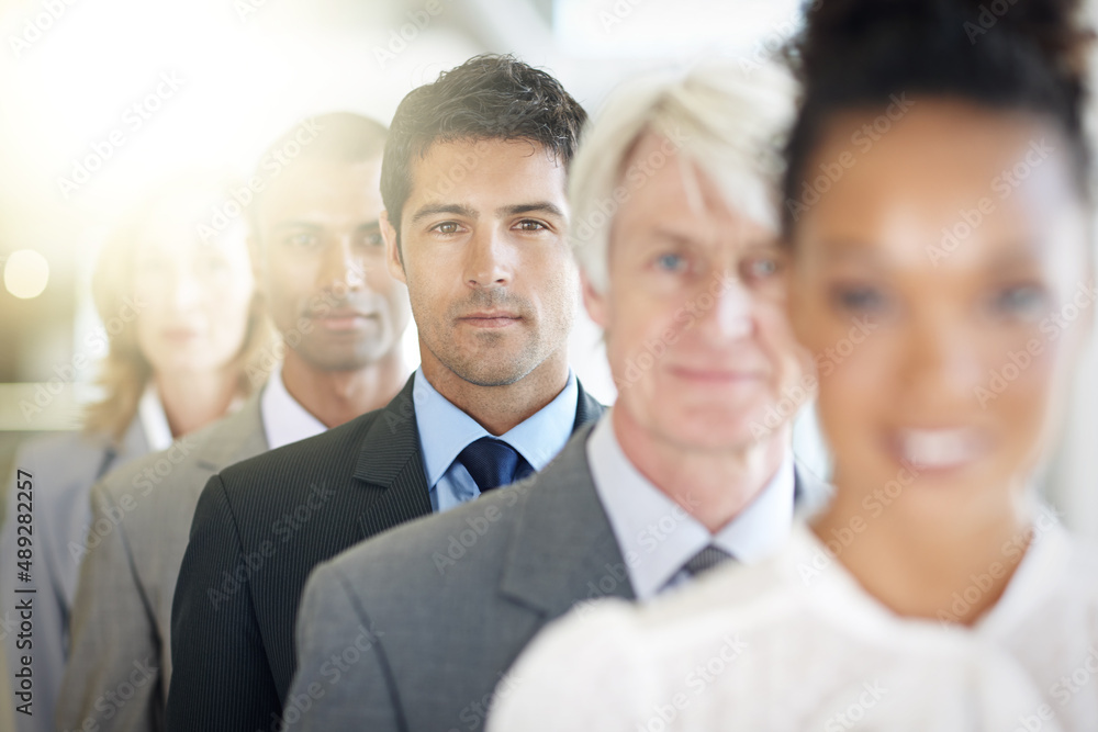 Corporate confidence. Cropped shot of a group of diverse businesspeople standing in a line. Corporate confidence. Cropped shot of a group of diverse businesspeople standing in a line.