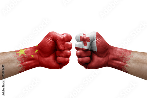 Two hands punch to each others on white background. Country flags painted fists, conflict crisis concept between china and tonga
