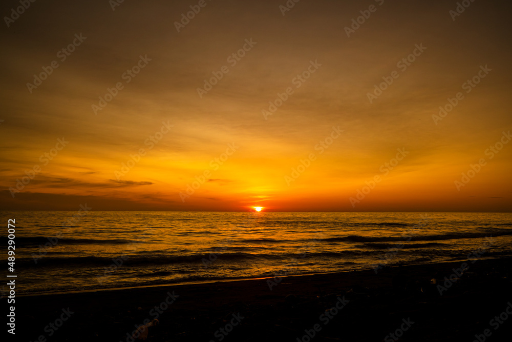 Beautiful seascape at sunset with dramatic golden sky