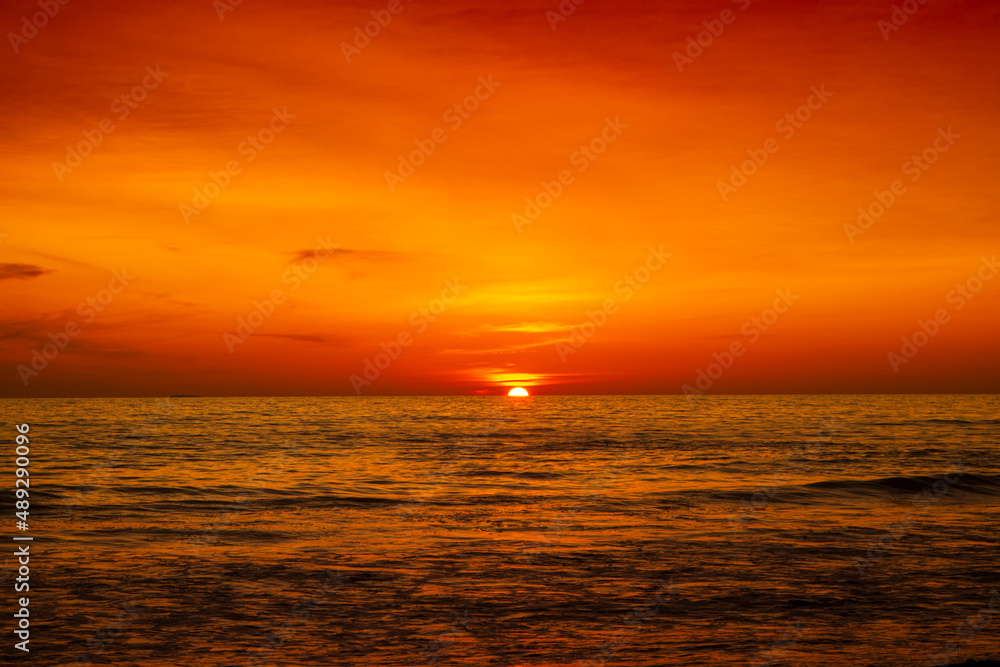 Beautiful sunset over ocean with orange and red sky