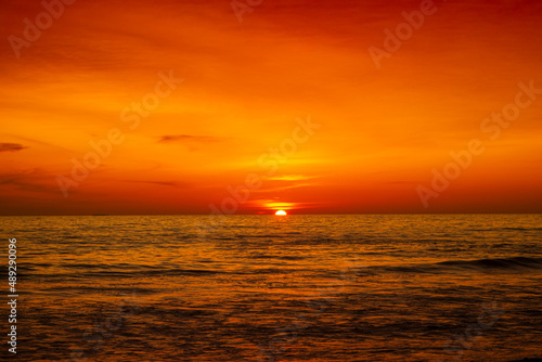Beautiful sunset over ocean with orange and red sky © Johnster Designs