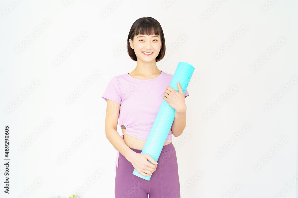 ヨガマットを持つ女性
