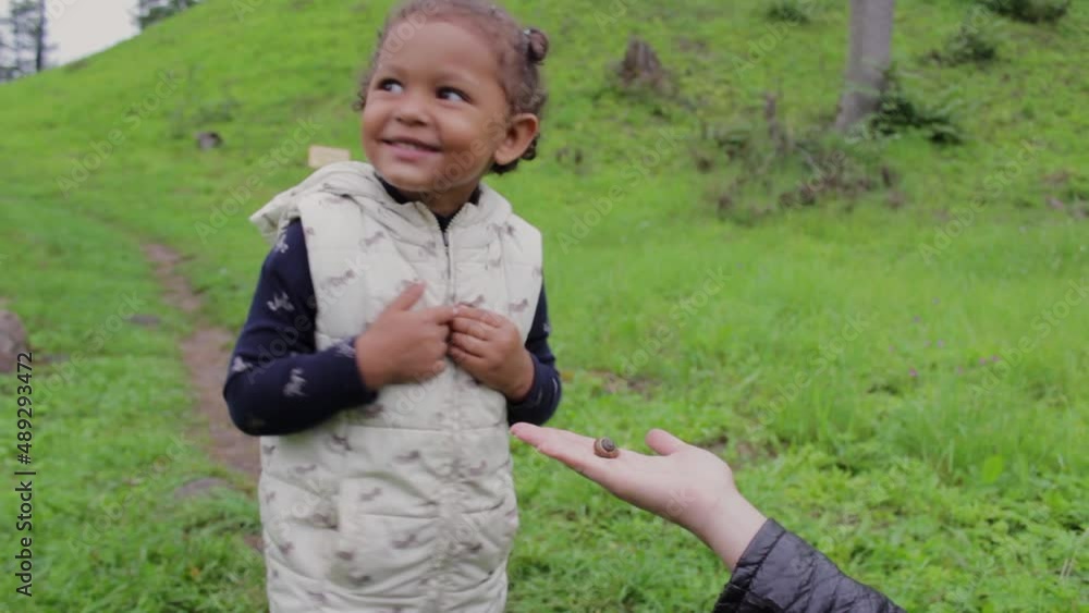 Overwhelmed little black girl touching a snail for the first time Overwhelmed little black girl touching a snail for the first time