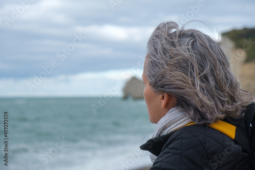 Profile view of older woman on cold beach