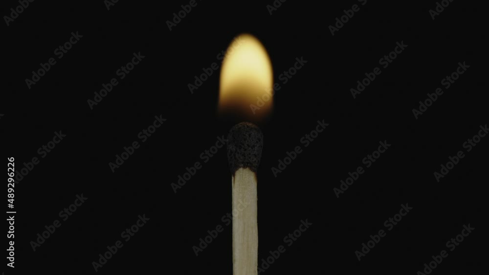 Shooting macro. A lighted match blazes on a black background. One match ignites another. Then the flame goes out. A wooden match with a sulfur head. Shooting macro. A lighted match blazes on a black background. One match ignites another. Then the flame goes out. A wooden match with a sulfur head.