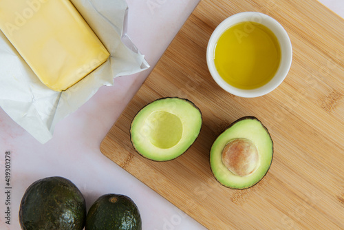 Still life of healthy fats including avocado, butter and olive oil photo