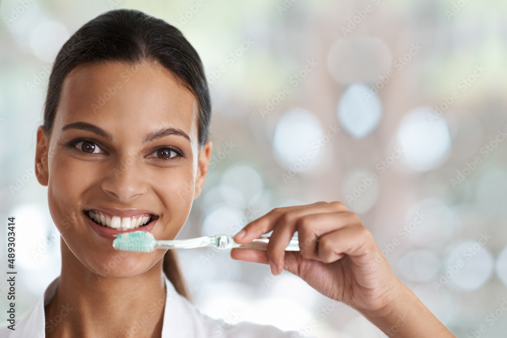 Brush everyday for a perfect smile. Portrait of a smiling woman holding a toothbrush. Brush everyday for a perfect smile. Portrait of a smiling woman holding a toothbrush.