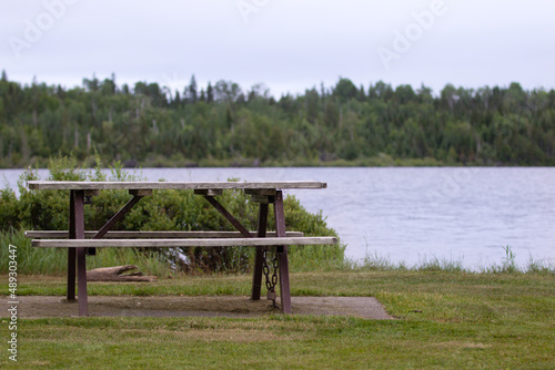 picnic table on a cloudy day by a lake in summer