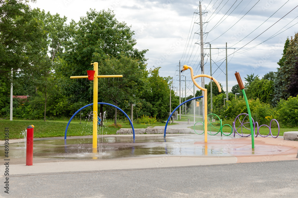 Splash pad playground in public park in summer without people. Fountain with splashing water