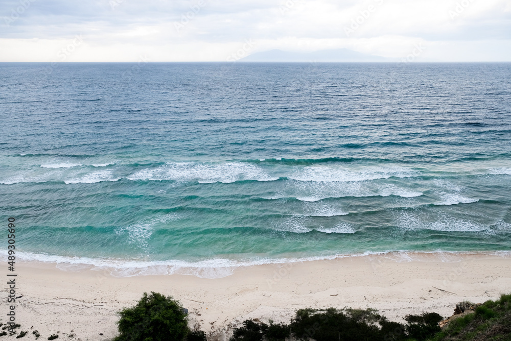 Beautiful view of Cristo Rei Backside Beach or known as Dolok Oan Beach in Dili, Timor Leste. Sea waves background. Aerial view of tropical beach. Beautiful view of Cristo Rei Backside Beach or known as Dolok Oan Beach in Dili, Timor Leste. Sea waves background. Aerial view of tropical beach.