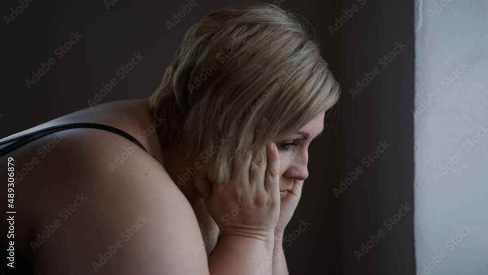 Depressed lonely fat woman sitting at home and thinking. Depressed lonely fat woman sitting at home and thinking.