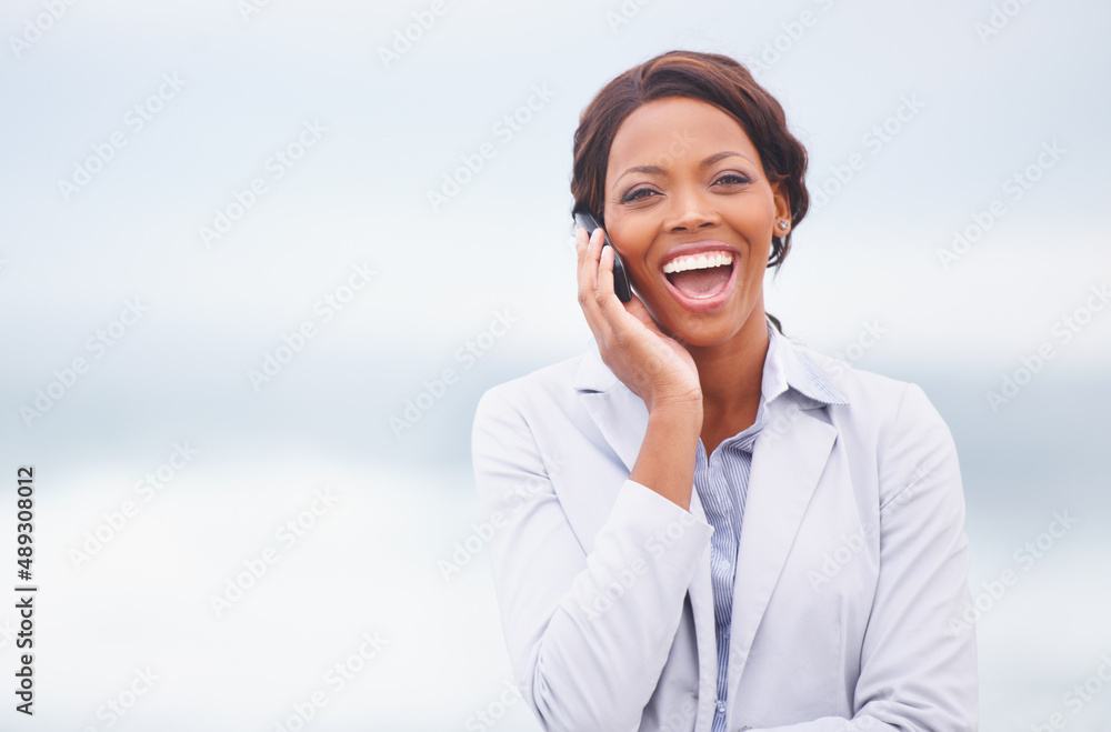 Laughter in the ocean breeze. A pretty african american woman having an enjoyable conversation while outdoors. Laughter in the ocean breeze. A pretty african american woman having an enjoyable conversation while outdoors.