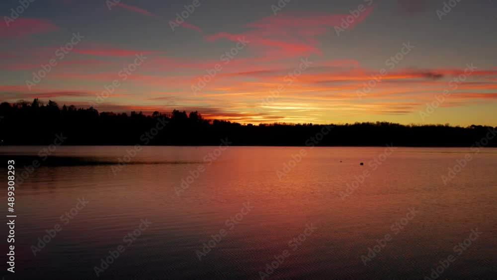 Beautiful Italian sunset on the lake with mountains in background. Orange, calm lake, Alps, Lake Como, Resegone. Beautiful Italian sunset on the lake with mountains in background. Orange, calm lake, Alps, Lake Como, Resegone.